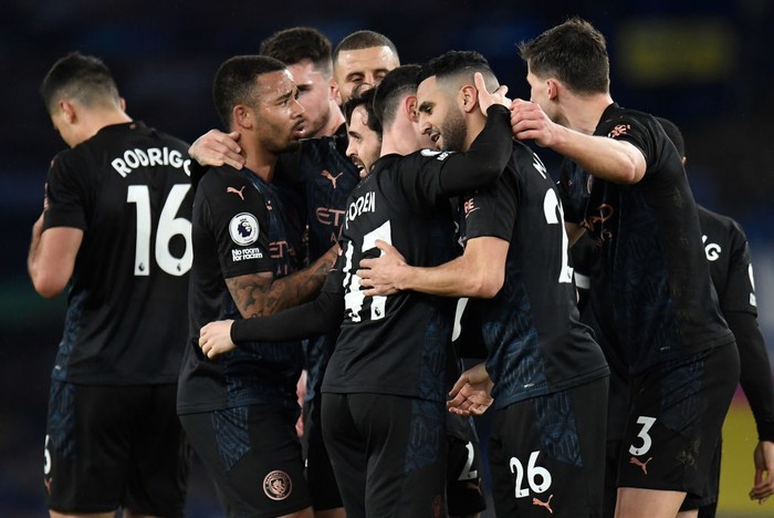 LIVERPOOL, ENGLAND - FEBRUARY 17: Riyad Mahrez of Manchester City is is congratulated by Phil Foden and team mates after scoring their sides second goal during the Premier League match between Everton and Manchester City at Goodison Park on February 17, 2021 in Liverpool, England. Sporting stadiums around the UK remain under strict restrictions due to the Coronavirus Pandemic as Government social distancing laws prohibit fans inside venues resulting in games being played behind closed doors. (Photo by Jon Super - Pool/Getty Images)