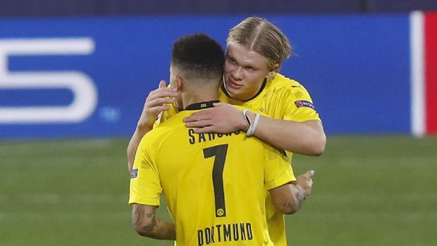 Dortmund's Erling Haaland, rear and Jadon Sancho embrace at the end of the Champions League, round of 16, first leg soccer match between Sevilla and Borussia Dortmund at the Ramon Sanchez Pizjuan stadium in Seville, Spain, Wednesday, Feb. 17, 2021. (AP Photo/Angel Fernandez)