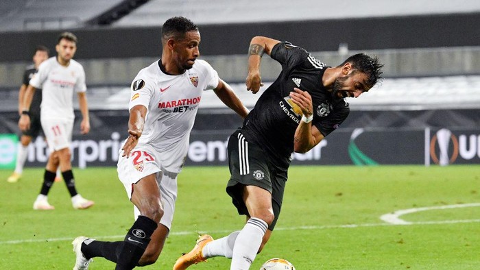 COLOGNE, GERMANY - AUGUST 16: Bruno Fernandes of Manchester United and Fernando of Sevilla FC  battle for the ball during the UEFA Europa League Semi Final between Sevilla and Manchester United at RheinEnergieStadion on August 16, 2020 in Cologne, Germany. (Photo by Martin Meissner/Pool via Getty Images)