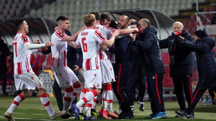 BELGRADE, SERBIA - FEBRUARY 18: Guelor Kanga of Crvena Zvezda (C) celebrates after scoring their sides first goal with Dejan Stankovic, manager of Crvena Zvezda during the UEFA Europa League Round of 32 match between Crvena Zvezda and AC Milan at Rajko Mitic Stadium on February 18, 2021 in Belgrade, Serbia. Sporting stadiums around Serbia remain under strict restrictions due to the Coronavirus Pandemic as Government social distancing laws prohibit fans inside venues resulting in games being played behind closed doors. (Photo by Srdjan Stevanovic/Getty Images)