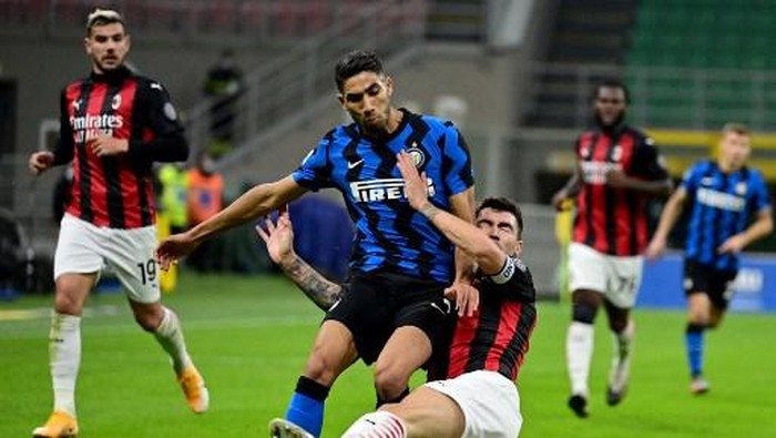 Inter Milans Moroccan defender Achraf Hakimi (L) fights for the ball with AC Milans Italian defender Alessio Romagnoli during the Italian Serie A football match between Inter Milan and AC Milan at the San Siro stadium in Milan on October 17, 2020. (Photo by Miguel MEDINA / AFP)