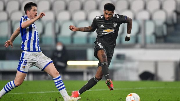 TURIN, ITALY - FEBRUARY 18: Marcus Rashford of Manchester United scores their sides third goal under pressure from Igor Zubeldia of Real Sociedad  during the UEFA Europa League Round of 32 match between Real Sociedad and Manchester United at Allianz Stadium on February 18, 2021 in Turin, Italy. Real Sociedad face Manchester United at a neutral venue in Turin behind closed doors after Spain imposed a ban on travellers arriving from the UK in an effort to prevent the spread of Covid-19 variants. (Photo by Valerio Pennicino/Getty Images)