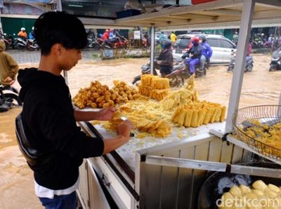 Santainya Pedagang Gorengan Jualan di Tengah Genangan Jatiasih