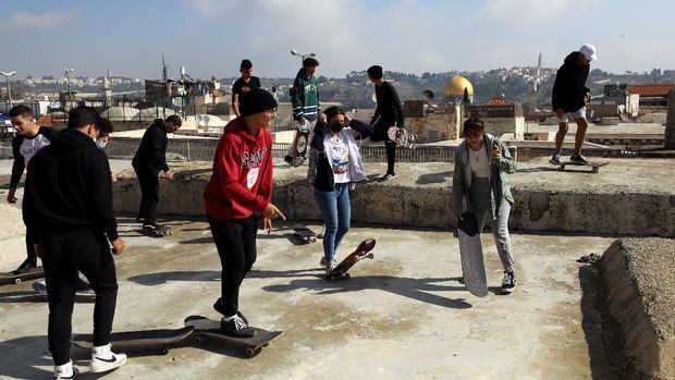 The Dome of the Rock located on the compound known to Muslims as Noble Sanctuary and to Jews as Temple Mount is seen in the background as Palestinian youths skateboard on rooftops, as Israel partially lifts its third national lockdown to fight the coronavirus disease (COVID-19) crisis, in Jerusalem's Old City February 7, 2021. Picture taken February 7, 2021. REUTERS/Ammar Awad