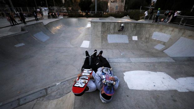 The Dome of the Rock located on the compound known to Muslims as Noble Sanctuary and to Jews as Temple Mount is seen in the background as Palestinian youths skateboard on rooftops, as Israel partially lifts its third national lockdown to fight the coronavirus disease (COVID-19) crisis, in Jerusalem's Old City February 7, 2021. Picture taken February 7, 2021. REUTERS/Ammar Awad