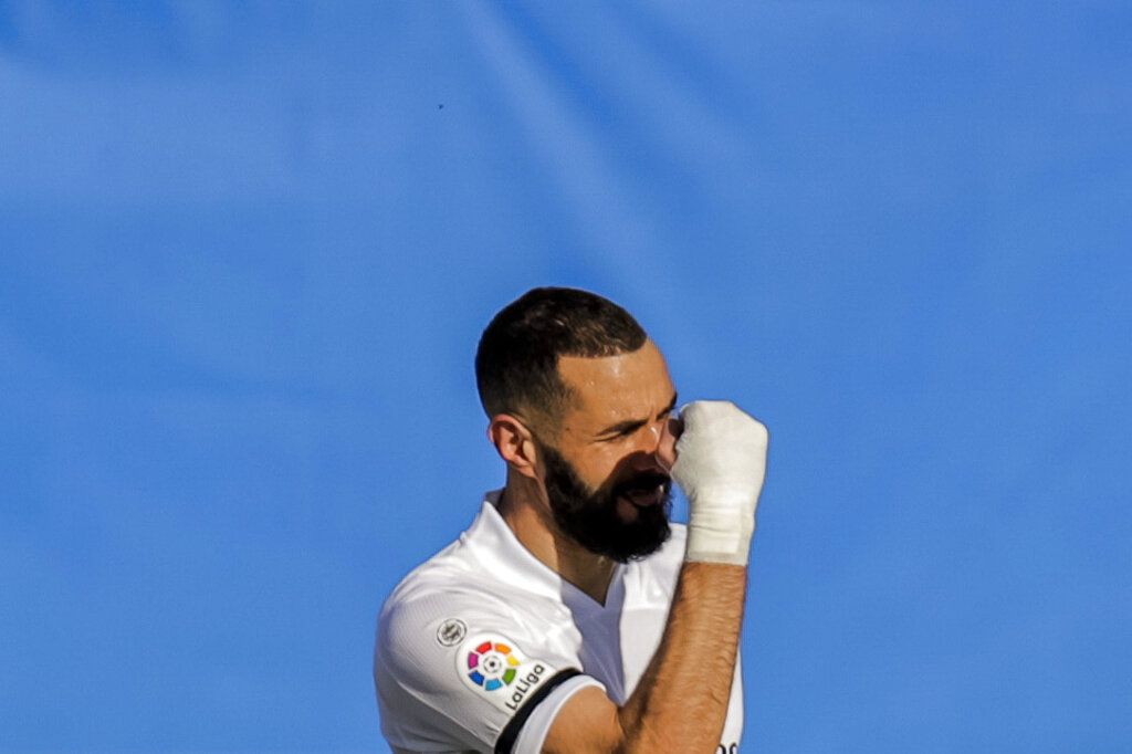 Real Madrid's Karim Benzema celebrates after scoring the opening goal during the Spanish La Liga soccer match between Real Madrid and Valencia at the Alfredo Di Stefano stadium in Madrid, Spain, Sunday, Feb. 14, 2021. (AP Photo/Manu Fernandez)