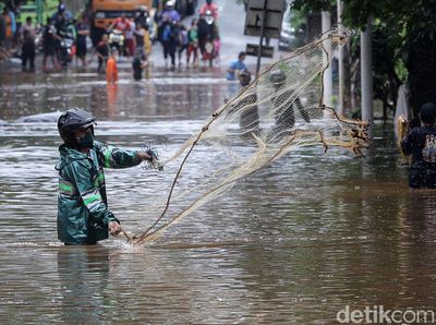 Menjala Ikan di Tengah Jalan TB Simatupang yang Kebanjiran