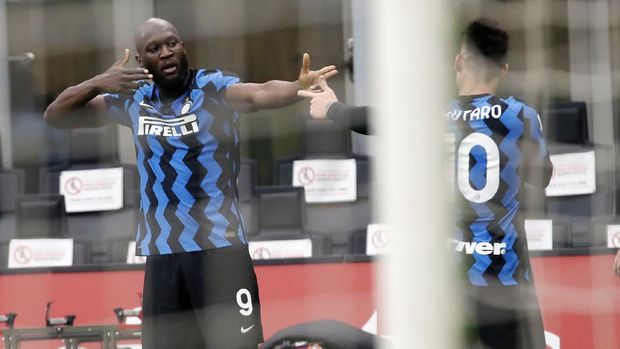 Inter Milan's Romelu Lukaku, left, celebrates with his teammate Lautaro Martinez after scoring his side's third goal during the Serie A soccer match between AC Milan and Inter Milan, at the Milan San Siro Stadium, Italy, Sunday, Feb. 21, 2021. (AP Photo/Antonio Calanni)