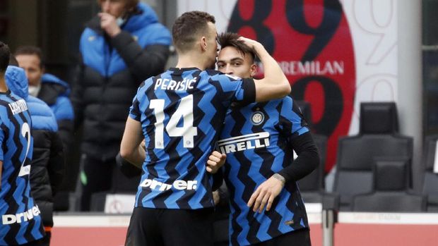 Inter Milan's Lautaro Martinez, right, celebrates with Ivan Perisic after scoring his side's second goal during the Serie A soccer match between AC Milan and Inter Milan, at the Milan San Siro Stadium, Italy, Sunday, Feb. 21, 2021. (AP Photo/Antonio Calanni)