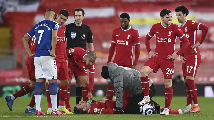 Liverpools Jordan Henderson lies injured on the ground and is attended to by a member of the Liverpool medical team during the English Premier League soccer match between Liverpool and Everton at Anfield in Liverpool, England, Saturday, Feb. 20, 2021. (Lawrence Griffiths/ Pool via AP)