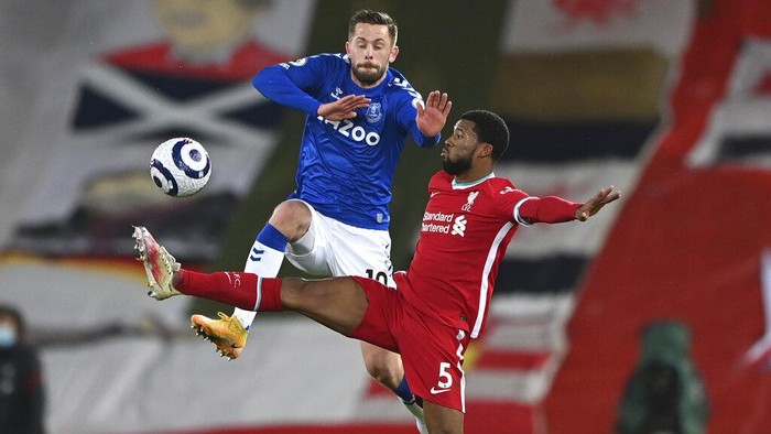 Evertons Gylfi Sigurdsson, leaps as he vies for the ball with Liverpools Georginio Wijnaldum during the English Premier League soccer match between Liverpool and Everton at Anfield in Liverpool, England, Saturday, Feb. 20, 2021. (Lawrence Griffiths/ Pool via AP)