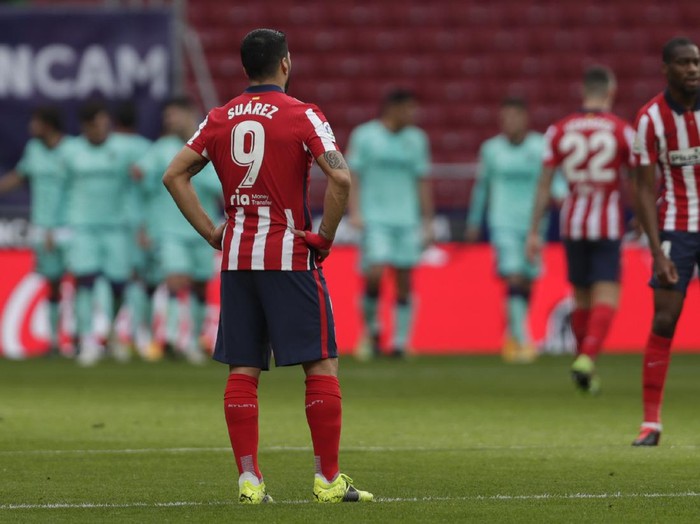 Atletico Madrids Luis Suarez, left, gestures as Levantes Jose Luis Morales celebrates with his teammates scoring his sides opening goal during the Spanish La Liga soccer match between Atletico Madrid and Levante at the Wanda Metropolitano stadium in Madrid, Spain, Saturday, Feb. 20, 2021. (AP Photo/Manu Fernandez)