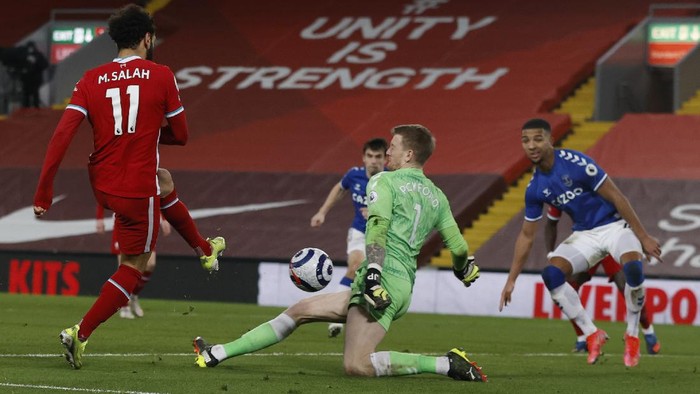 Liverpools Mohamed Salah, left shoots at goal only to have his shot blocked by Evertons goalkeeper Jordan Pickford during the English Premier League soccer match between Liverpool and Everton at Anfield in Liverpool, England, Saturday, Feb. 20, 2021. (Phil Noble/ Pool via AP)