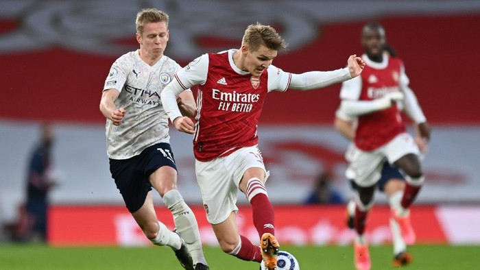 LONDON, ENGLAND - FEBRUARY 21: Martin Odegaard of Arsenal battles for possession with Oleksandr Zinchenko of Manchester City during the Premier League match between Arsenal and Manchester City at Emirates Stadium on February 21, 2021 in London, England. Sporting stadiums around the UK remain under strict restrictions due to the Coronavirus Pandemic as Government social distancing laws prohibit fans inside venues resulting in games being played behind closed doors. (Photo by Shaun Botterill/Getty Images)