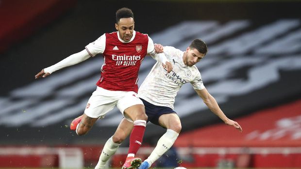 Arsenal's Pierre-Emerick Aubameyang, left, and Manchester City's Ruben Dias challenge for the ball during the English Premier League soccer match between Arsenal and Manchester City at the Emirates stadium in London, England, Sunday, Feb. 21, 2021. (Julian Finney/Pool via AP)