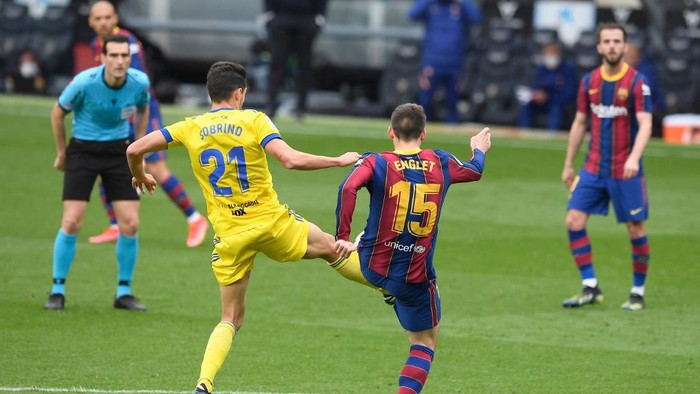 Barcelonas French defender Clement Lenglet (R) challenges Cadizs Spanish midfielder Ruben Sobrino during the Spanish league football match between FC Barcelona and Cadiz CF at the Camp Nou stadium in Barcelona on February 21, 2021. (Photo by Josep LAGO / AFP)