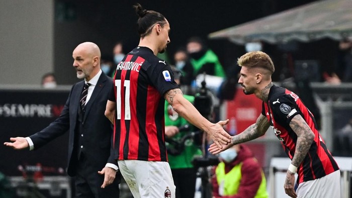 AC Milans Swedish forward Zlatan Ibrahimovic (C) taps hand with AC Milans Spanish forward Samuel Castillejo (R) as he is being substituted by AC Milans Italian coach Stefano Pioli (Rear L) during the Italian Serie A football match AC Milan vs Inter Milan on February 21, 2021 at the San Siro stadium in Milan. (Photo by MIGUEL MEDINA / AFP)
