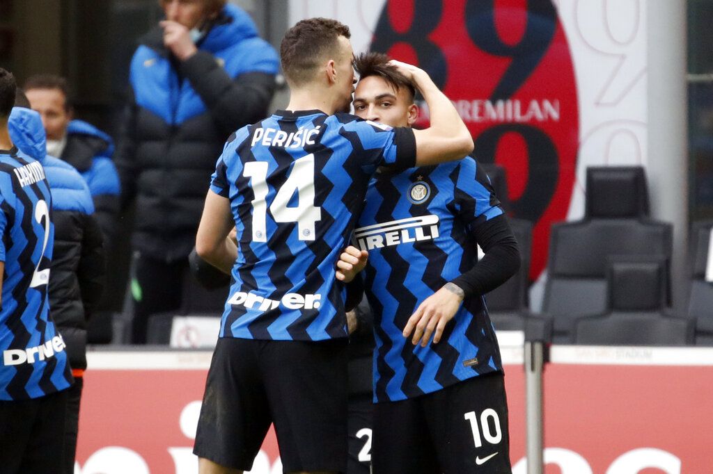 AC Milan's Alexis Saelemaekers, left, and Inter's Ivan Perisic go for the ball during the Serie A soccer match between AC Milan and Inter Milan, at the San Siro Stadium in Milan, Italy, Sunday, Feb. 21, 2021. (Marco Alpozzi/LaPresse via AP)