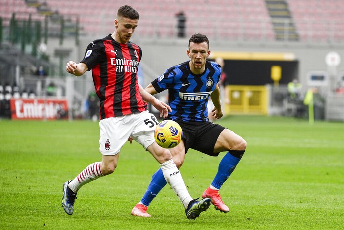 AC Milans Alexis Saelemaekers, left, and Inters Ivan Perisic go for the ball during the Serie A soccer match between AC Milan and Inter Milan, at the San Siro Stadium in Milan, Italy, Sunday, Feb. 21, 2021. (Marco Alpozzi/LaPresse via AP)