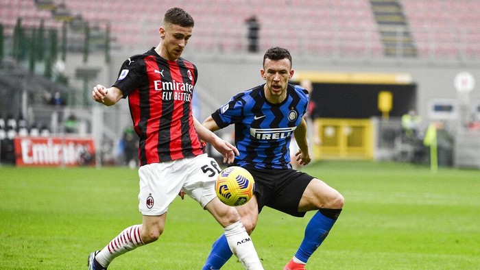 AC Milans Alexis Saelemaekers, left, and Inters Ivan Perisic go for the ball during the Serie A soccer match between AC Milan and Inter Milan, at the San Siro Stadium in Milan, Italy, Sunday, Feb. 21, 2021. (Marco Alpozzi/LaPresse via AP)