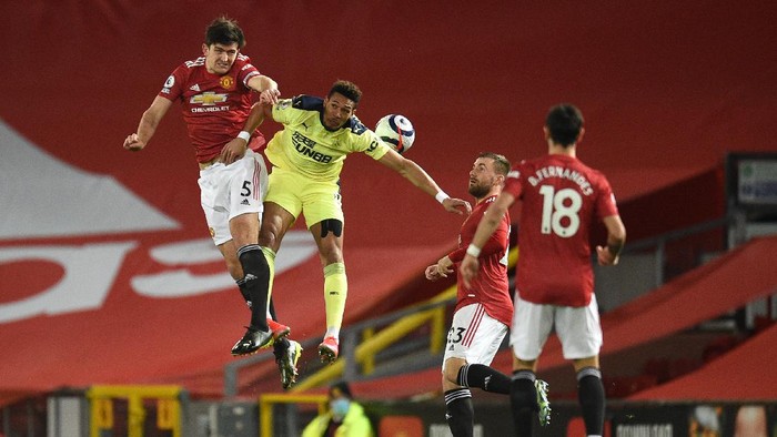 MANCHESTER, ENGLAND - FEBRUARY 21: Harry Maguire of Manchester United battles for possession with Joelinton of Newcastle United during the Premier League match between Manchester United and Newcastle United at Old Trafford on February 21, 2021 in Manchester, England. Sporting stadiums around the UK remain under strict restrictions due to the Coronavirus Pandemic as Government social distancing laws prohibit fans inside venues resulting in games being played behind closed doors. (Photo by Oli Scarff - Pool/Getty Images)