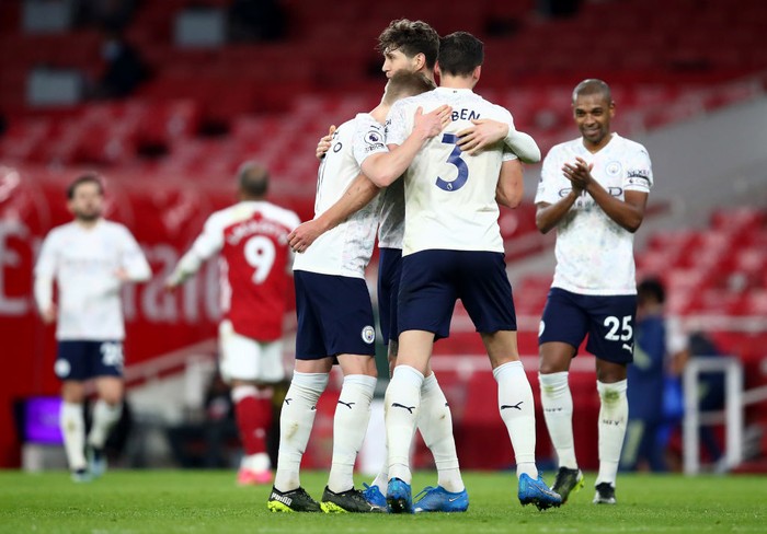 LONDON, ENGLAND - FEBRUARY 21: Ruben Dias of Manchester City celebrates victory with Oleksandr Zinchenko and John Stones after the Premier League match between Arsenal and Manchester City at Emirates Stadium on February 21, 2021 in London, England. Sporting stadiums around the UK remain under strict restrictions due to the Coronavirus Pandemic as Government social distancing laws prohibit fans inside venues resulting in games being played behind closed doors. (Photo by Julian Finney/Getty Images)