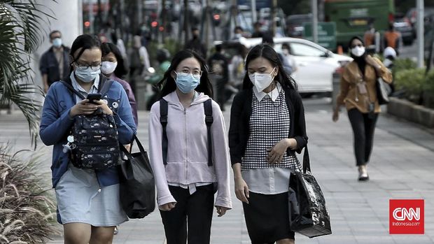 Pekerja melintas di Jalan Jenderal  Sudirman. Jakarta,  Senin (22/2/2021). Peraturan Pemerintah (PP) nomor 35 tahun 2021 yang ditandatangani Presiden Joko Widodo pada 2 Februari lalu memperbolehkan perusahaan untuk tidak membayar penuh pesangon karyawan yang terkena pemutusan hubungan kerja (PHK) dalam keadaan tertentu. CNN Indonesia/Andry Novelino