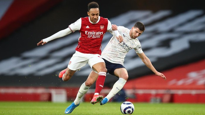 LONDON, ENGLAND - FEBRUARY 21: Ruben Dias of Manchester City battles for possession with Pierre Emerick Aubameyang of Arsenal during the Premier League match between Arsenal and Manchester City at Emirates Stadium on February 21, 2021 in London, England. Sporting stadiums around the UK remain under strict restrictions due to the Coronavirus Pandemic as Government social distancing laws prohibit fans inside venues resulting in games being played behind closed doors. (Photo by Julian Finney/Getty Images)