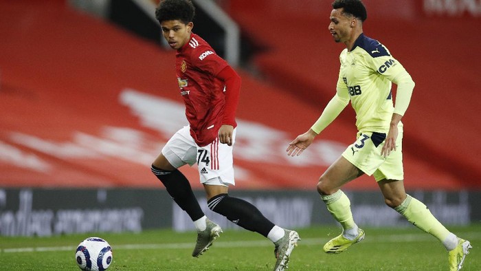 Manchester Uniteds Shola Shoretire, left, controls the ball in front of Newcastles Jacob Murphy during an English Premier League soccer match between Manchester United and Newcastle at the Old Trafford stadium in Manchester, England, Sunday Feb. 21, 2021. (Phil Noble/Pool via AP)