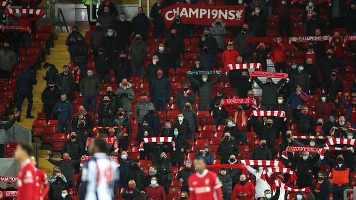 LIVERPOOL, ENGLAND - DECEMBER 27: Liverpool fans sing in their socially-distanced seats during the Premier League match between Liverpool and West Bromwich Albion at Anfield on December 27, 2020 in Liverpool, England. A limited number of fans (2000) are welcomed back to stadiums to watch elite football across England. This was following easing of restrictions on spectators in tiers one and two areas only. (Photo by Nick Potts - Pool/Getty Images)