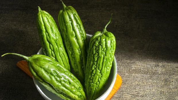 Fresh bitter melon or pare on white bowl. healty vegetable with contains many nutrients that are good for the body. dark background