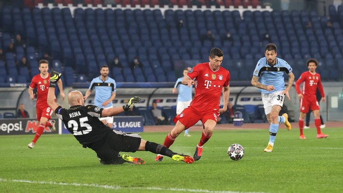 ROME, ITALY - FEBRUARY 23: Robert Lewandowski of FC Bayern Muenchen goes around Pepe Reina of S.S. Lazio to go on and score their sides first goal during the UEFA Champions League Round of 16 match between Lazio Roma and Bayern München at Olimpico Stadium on February 23, 2021 in Rome, Italy. Sporting stadiums around Italy remain under strict restrictions due to the Coronavirus Pandemic as Government social distancing laws prohibit fans inside venues resulting in games being played behind closed doors. (Photo by Alexander Hassenstein/Getty Images)