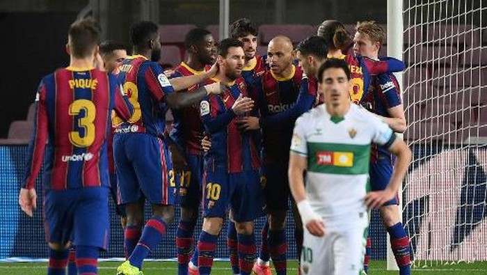 Barcelonas Argentinian forward Lionel Messi (C) celebrates with teammates after scoring a goal during the Spanish league football match between FC Barcelona and Elche CF at the Camp Nou stadium in Barcelona on February 24, 2021. (Photo by LLUIS GENE / AFP)