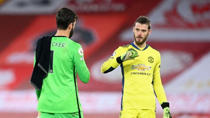 LIVERPOOL, ENGLAND - JANUARY 17: Alisson Becker of Liverpool interacts with David De Gea of Manchester United after the Premier League match between Liverpool and Manchester United at Anfield on January 17, 2021 in Liverpool, England. Sporting stadiums around England remain under strict restrictions due to the Coronavirus Pandemic as Government social distancing laws prohibit fans inside venues resulting in games being played behind closed doors. (Photo by Michael Regan/Getty Images)