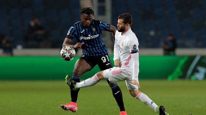 BERGAMO, ITALY - FEBRUARY 24: Duvan Zapata of Atalanta is challenged by Nacho of Real Madrid during the UEFA Champions League Round of 16 match between Atalanta and Real Madrid at Gewiss Stadium on February 24, 2021 in Bergamo, Italy. Sporting stadiums around Italy remain under strict restrictions due to the Coronavirus Pandemic as Government social distancing laws prohibit fans inside venues resulting in games being played behind closed doors. (Photo by Emilio Andreoli/Getty Images)