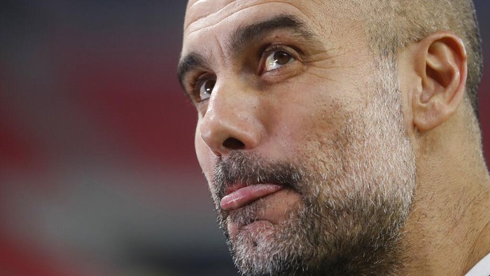 Manchester Citys head coach Pep Guardiola grimaces ahead of the Champions League round of 16 first leg soccer match between Borussia Monchengladbach and Manchester City at the Puskas Arena stadium in Budapest, Hungary, Wednesday, Feb. 24, 2021. (AP Photo/Laszlo Balogh)