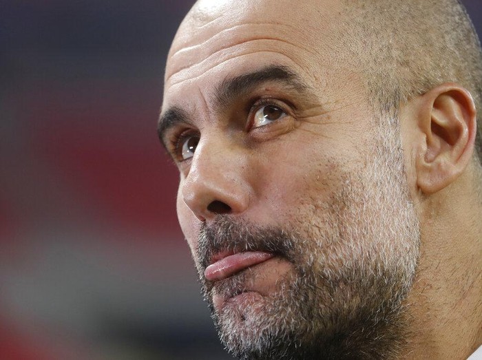 Manchester City's head coach Pep Guardiola grimaces ahead of the Champions League round of 16 first leg soccer match between Borussia Monchengladbach and Manchester City at the Puskas Arena stadium in Budapest, Hungary, Wednesday, Feb. 24, 2021. (AP Photo/Laszlo Balogh)