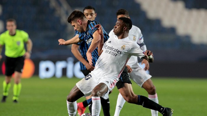 BERGAMO, ITALY - FEBRUARY 24: Vinicius Junior of Real Madrid battles for possession with Berat Djimsiti of Atalanta B.C. during the UEFA Champions League Round of 16 match between Atalanta and Real Madrid at Gewiss Stadium on February 24, 2021 in Bergamo, Italy. Sporting stadiums around Italy remain under strict restrictions due to the Coronavirus Pandemic as Government social distancing laws prohibit fans inside venues resulting in games being played behind closed doors. (Photo by Emilio Andreoli/Getty Images)