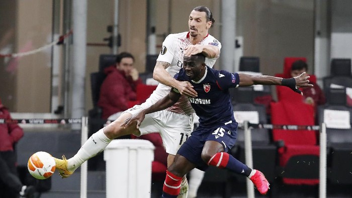 AC Milans Zlatan Ibrahimovic, left, challenges for the ball with Red Stars Sekou Sanogo during the Europa League round of 32 second leg soccer match between AC Milan and Red Star Belgrade at the San Siro Stadium, in Milan, Italy, Thursday, Feb. 25, 2021. (AP Photo/Antonio Calanni)