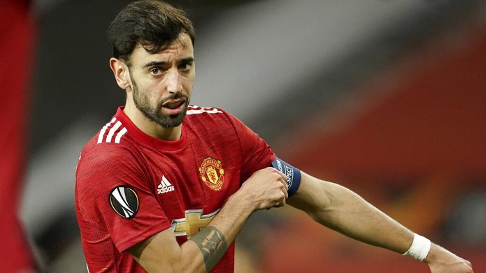 Manchester Uniteds Bruno Fernandes adjusts his captain armband during the Europa League round of 32, second leg, soccer match between Manchester United and Real Sociedad at Old Trafford in Manchester, England, Thursday, Feb. 25, 2021. (AP Photo/Dave Thompson)