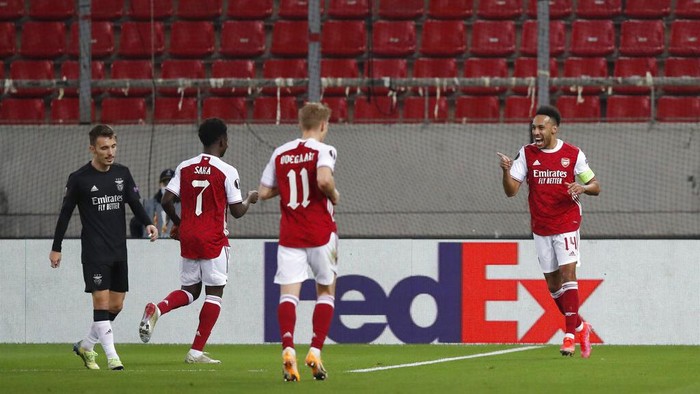 Arsenals Pierre-Emerick Aubameyang, right, celebrates with teammates after scoring the opening goal during the Europa League second leg soccer match between Arsenal and Benfica at Georgios Karaiskakis stadium, in Piraeus port, near Athens, Thursday, Feb. 25, 2021. (AP Photo/Thanassis Stavrakis)