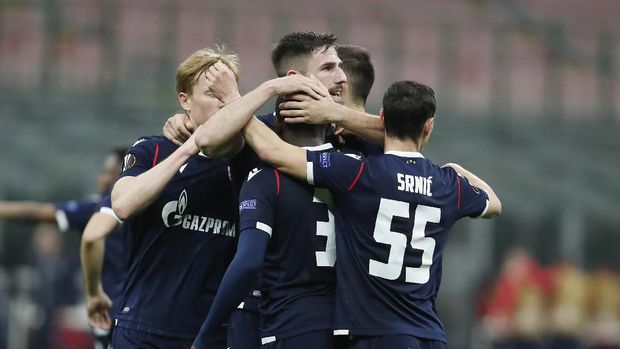 Red Star's Fardou Ben, covered by his teammates, celebrates after scoring his team's first goal during the Europa League round of 32 second leg match between AC Milan and Red Star Belgrade at the San Siro Stadium, in Milan, Italy, on Thursday, February 2.  25, 2021. (AP Photo / Antonio Calanni)