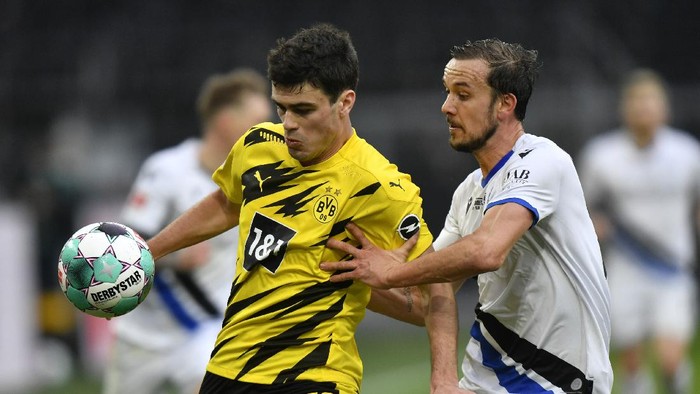 Dortmunds Giovanni Reyna, left, challenges for the ball with Arminias Manuel Prietl during the German Bundesliga soccer match between Borussia Dortmund and Arminia Bielefeld in Dortmund, Germany, Saturday, Feb. 27, 2021. (AP Photo/Martin Meissner, Pool)