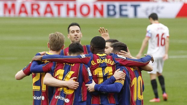 Barcelona's Ousmane Dembele, center back to camera, celebrates with teammates after scoring during a Spanish La Liga soccer match between Sevilla and Barcelona at the Ramon Sanchez-Pizjuan stadium in Seville, Spain, Saturday Feb. 27, 2021. (AP Photo/Angel Fernandez)