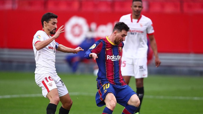 SEVILLE, SPAIN - FEBRUARY 27: Lionel Messi of FC Barcelona is challenged by Jesus Navas of Sevilla on his way to scoring his teams second goal during the La Liga Santander match between Sevilla FC and FC Barcelona at Estadio Ramon Sanchez Pizjuan on February 27, 2021 in Seville, Spain. Sporting stadiums around Spain remain under strict restrictions due to the Coronavirus Pandemic as Government social distancing laws prohibit fans inside venues resulting in games being played behind closed doors. (Photo by Fran Santiago/Getty Images)