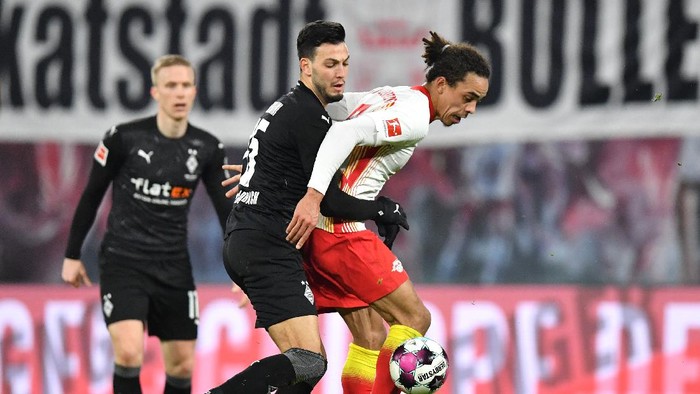 LEIPZIG, GERMANY - FEBRUARY 27: Yussuf Poulsen of RB Leipzig is challenged by Ramy Bensebaini of Borussia Moenchengladbach during the Bundesliga match between RB Leipzig and Borussia Moenchengladbach at Red Bull Arena on February 27, 2021 in Leipzig, Germany. Sporting stadiums around Germany remain under strict restrictions due to the Coronavirus Pandemic as Government social distancing laws prohibit fans inside venues resulting in games being played behind closed doors. (Photo by Stuart Franklin/Getty Images)