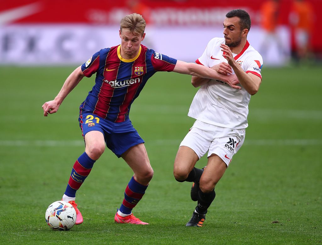 SEVILLE, SPAIN - FEBRUARY 27: Frenkie de Jong of FC Barcelona holds off Joan Jordan of Sevilla during the La Liga Santander match between Sevilla FC and FC Barcelona at Estadio Ramon Sanchez Pizjuan on February 27, 2021 in Seville, Spain. Sporting stadiums around Spain remain under strict restrictions due to the Coronavirus Pandemic as Government social distancing laws prohibit fans inside venues resulting in games being played behind closed doors. (Photo by Fran Santiago/Getty Images)