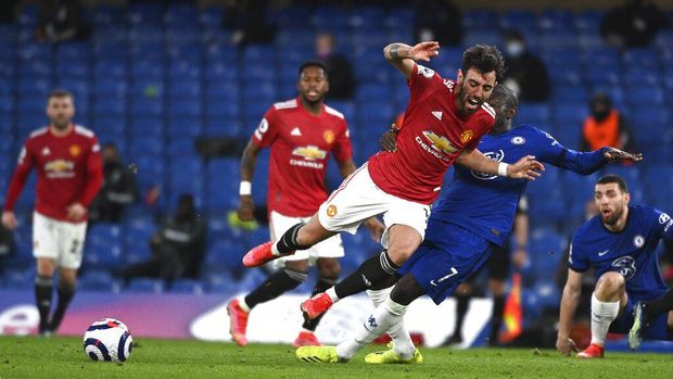 Manchester United's Bruno Fernandes, centre, and Chelsea's N'Golo Kante challenge for the ball during the English Premier League soccer match between Chelsea and Manchester United at Stamford Bridge Stadium in London, England, Sunday, Feb. 28, 2021. (Andy Rain/Pool via AP)