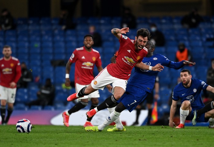 LONDON, ENGLAND - FEBRUARY 28: Bruno Fernandes of Manchester United is tackled by NGolo Kante of Chelsea  during the Premier League match between Chelsea and Manchester United at Stamford Bridge on February 28, 2021 in London, England. Sporting stadiums around the UK remain under strict restrictions due to the Coronavirus Pandemic as Government social distancing laws prohibit fans inside venues resulting in games being played behind closed doors. (Photo by Andy Rain - Pool/Getty Images)