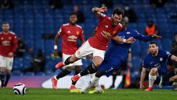 LONDON, ENGLAND - FEBRUARY 28: Bruno Fernandes of Manchester United is tackled by NGolo Kante of Chelsea  during the Premier League match between Chelsea and Manchester United at Stamford Bridge on February 28, 2021 in London, England. Sporting stadiums around the UK remain under strict restrictions due to the Coronavirus Pandemic as Government social distancing laws prohibit fans inside venues resulting in games being played behind closed doors. (Photo by Andy Rain - Pool/Getty Images)